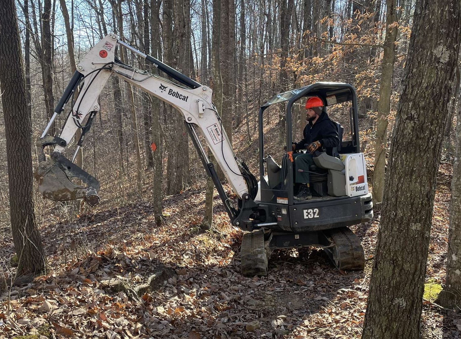 Dalton using Mini crane machine to clear brush and debris in the forest
